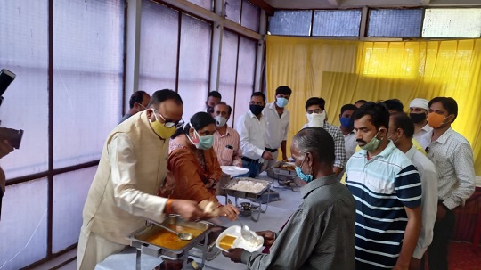 बुजेश पाठक भोजन वितरण करते हुए